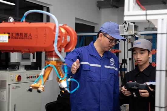 湖南铁道职业技术学院刘海龙老师指导学生进行工业机器人基础应用实训。万磊/摄